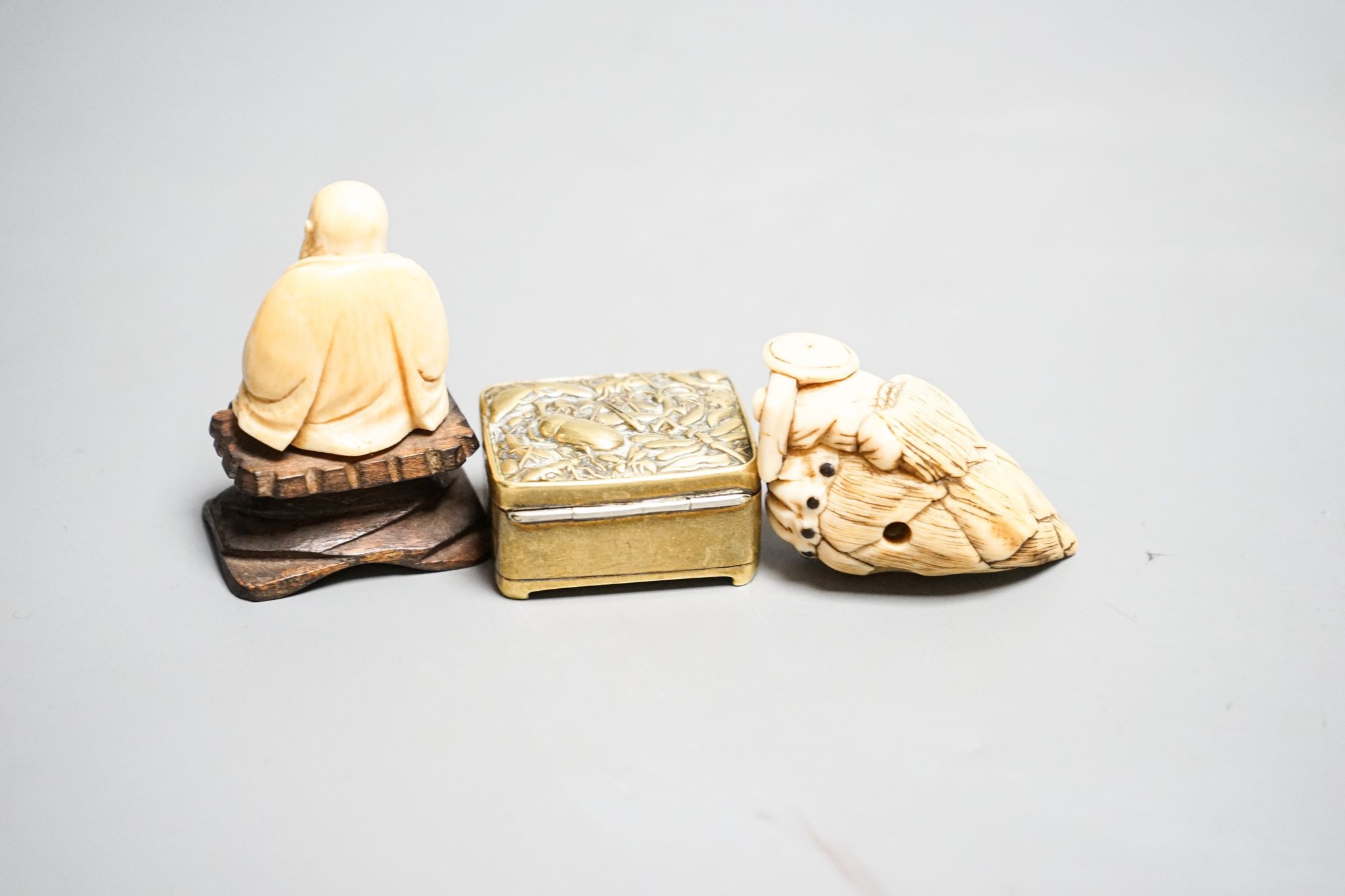 19th-century Japanese Ivory netsuke a man on a bamboo shoot, an ivory figure of Budai and a Japanese embossed brass box 5cm